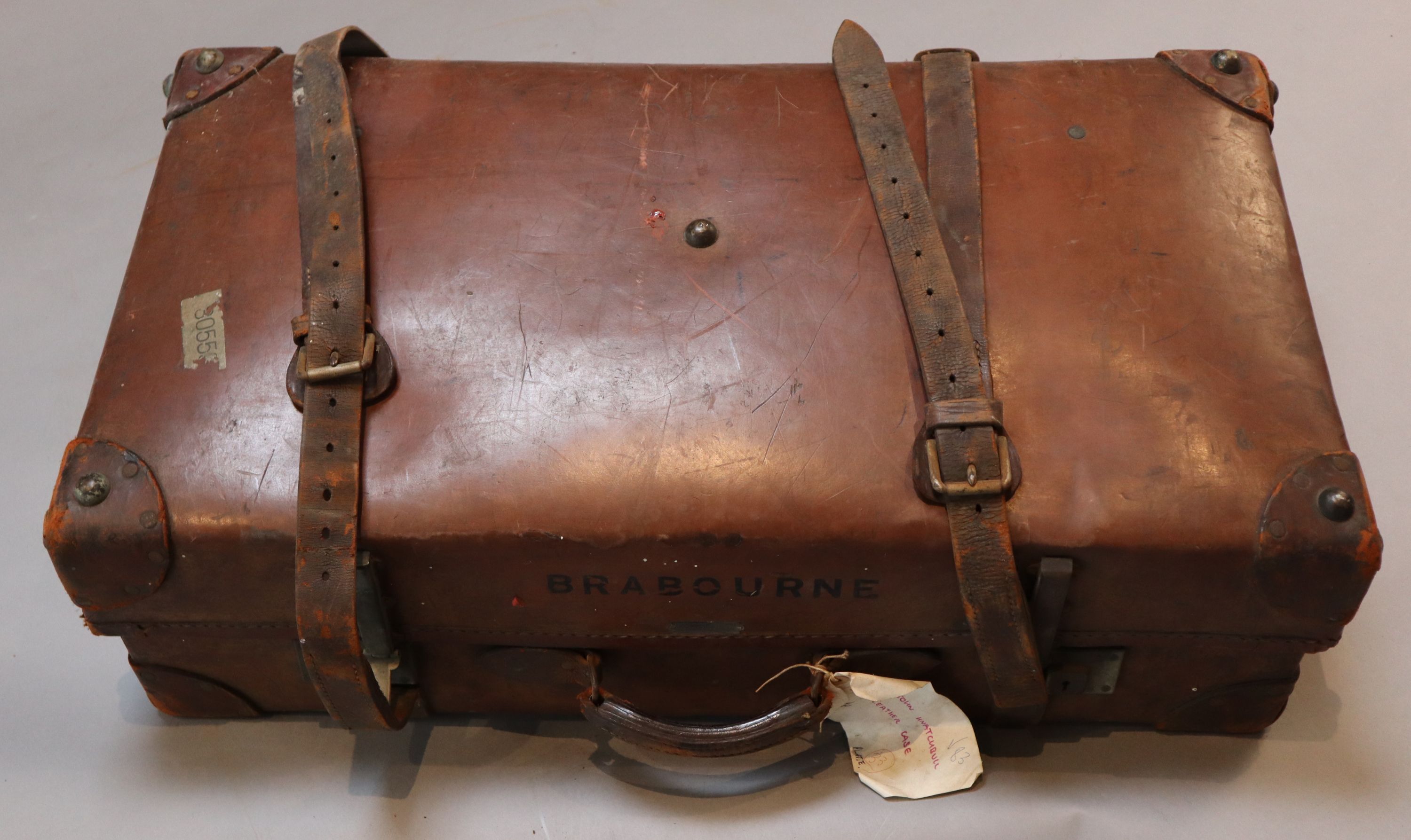 A group of three tan leather suitcases, one inscribed Brabourne, another Marchioness of Sligo